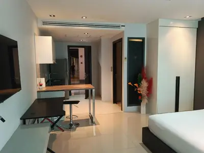 a bedroom with a desk and a bed and a table at Emerald Terrace Serenity 11 - 5th Floor Garden View by PSR in Patong Beach