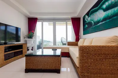 a living room with a couch and a television at ELEGANT Kata sea View Apartmens in Kata Beach