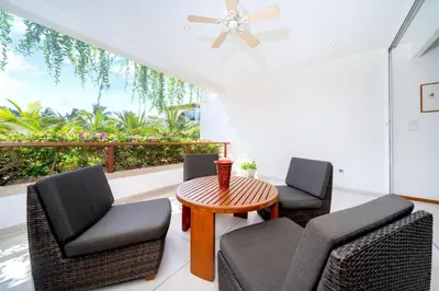 a patio with two chairs and a table and a ceiling fan at Luxury Flat 2BR at CHAVA 5-Star Resort in Surin Beach