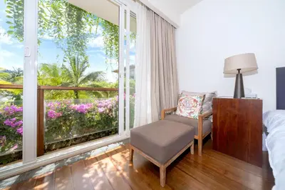 a bedroom with a bed and a window with a chair at Luxury Flat 2BR at CHAVA 5-Star Resort in Surin Beach