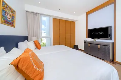 a bedroom with a white bed and a television at Luxury Flat 2BR at CHAVA 5-Star Resort in Surin Beach