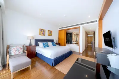 a bedroom with a bed and a desk and a television at Luxury Flat 2BR at CHAVA 5-Star Resort in Surin Beach