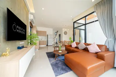 a living room with a couch and a tv at Goldena Twin Private Pool Villas in Kamala Beach