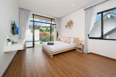 a bedroom with a bed and a large window at Goldena Twin Private Pool Villas in Kamala Beach
