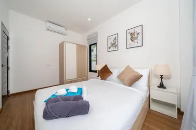a bedroom with a white bed with towels on it at Goldena Twin Private Pool Villas in Kamala Beach