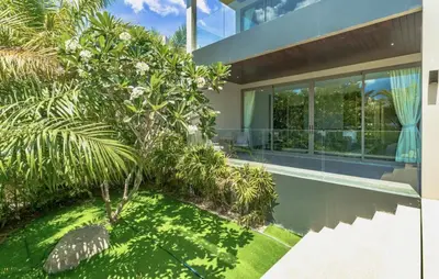 a house with a swimming pool and trees at Villa Lion Phuket in Phuket