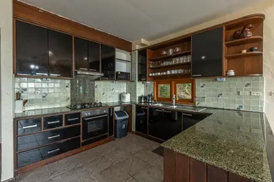 a large kitchen with wooden cabinets and counters at Villa Moon Talay Panorama View in Patong Beach