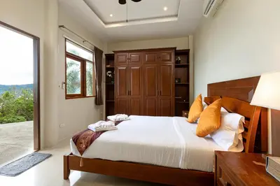 a bedroom with a large bed and a window at Villa Moon Talay Panorama View in Patong Beach