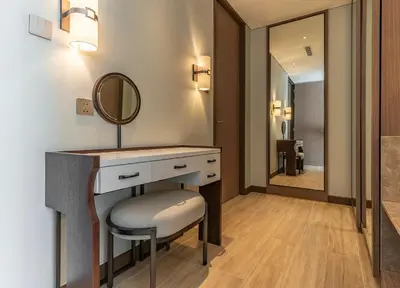 a bathroom with a vanity with a mirror and a stool at Infinite Ocean Retreats at Angsana Oceanview in Laguna Phuket