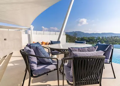 a patio with a table and chairs and a pool at Infinite Ocean Retreats at Angsana Oceanview in Laguna Phuket