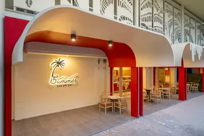 a restaurant with a palm tree sign on the wall at Summer Sea Phi Phi Island in Phi Phi Don