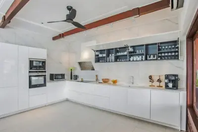 a kitchen with white cabinets and a ceiling fan at Luxury Seaview 6 Bedrooms with Infinity Pool Villa, private Gym, Superfast WIFI in Surin Beach