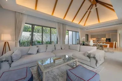 a living room with a white couch and a glass table at Spacious 4BR Private 15m Pool Villa Anchan V10 in Gated Residence in Bang Tao Beach