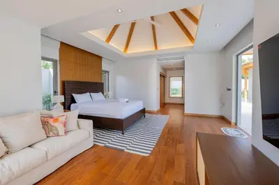 a living room with a bed and a couch at Spacious 4BR Private 15m Pool Villa Anchan V10 in Gated Residence in Bang Tao Beach