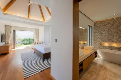 a bedroom with a bed and a bathroom with a tub at Spacious 4BR Private 15m Pool Villa Anchan V10 in Gated Residence in Bang Tao Beach