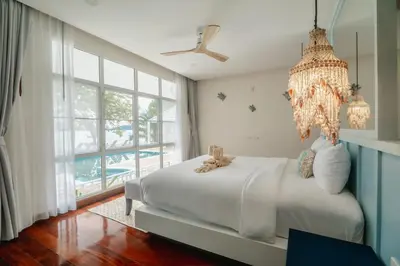 a bedroom with a large bed and a chandelier at Seaside Bliss Beach Villa Rawai in Rawai Beach