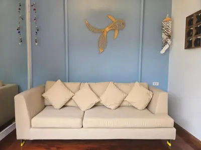 a living room with a white couch and a fish clock at Seaside Bliss Beach Villa Rawai in Rawai Beach