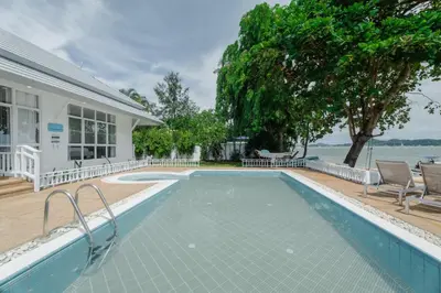 a swimming pool in front of a house at Seaside Bliss Beach Villa Rawai in Rawai Beach