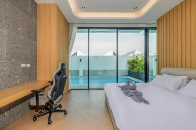 a bedroom with a bed and a desk and a chair at Bangtao Pool Villa with Home Cinema - PrymaVista in Phuket