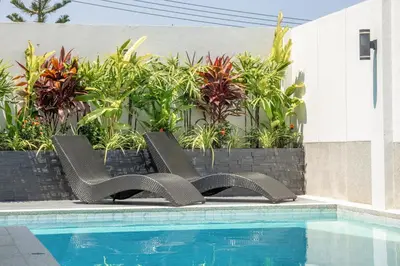 two chairs sitting next to a swimming pool at Bangtao Pool Villa with Home Cinema - PrymaVista in Phuket