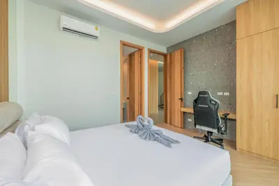 a bedroom with a bed and a desk with a computer at Bangtao Pool Villa with Home Cinema - PrymaVista in Phuket