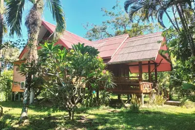 a resort with a red roof and palm trees at Leamsai House in Ban Laem Sai