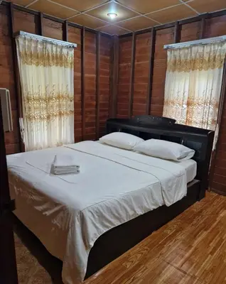 a bedroom with a large bed and two windows at Leamsai House in Ban Laem Sai