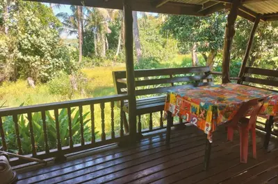a table and bench on a porch with a view at Leamsai House in Ban Laem Sai