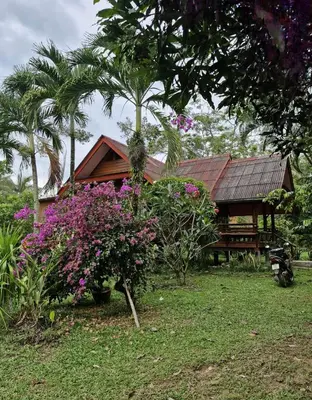 a house with a bench and some flowers at Leamsai House in Ban Laem Sai