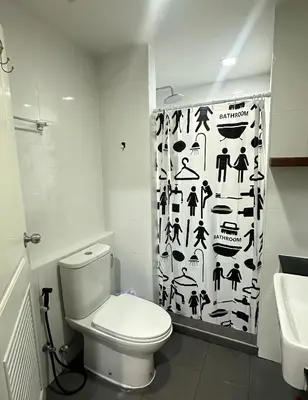 a bathroom with a toilet and a shower curtain at Connext Condominium By January in Ban Tha Khreng