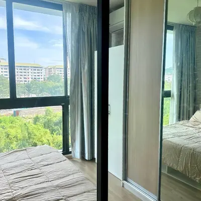 a bedroom with a bed and a large window at Connext Condominium By January in Ban Tha Khreng