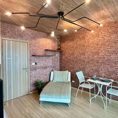 a room with a brick wall and a table and chairs at Connext Condominium By January in Ban Tha Khreng