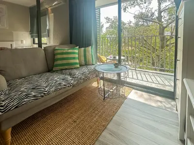 a living room with a couch and a balcony at Apartments pool view in Title Residence Naiyang in Nai Yang Beach