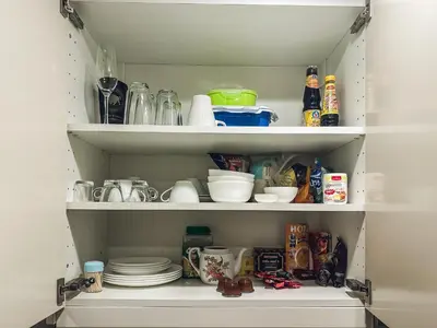 a pantry filled with dishes and other kitchen items at Apartments pool view in Title Residence Naiyang in Nai Yang Beach