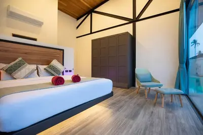a bedroom with a large white bed and a blue chair at New, Modern & Stylish 17m Eco Pool Villa Sunset Garden 11 in Rawai in Rawai Beach