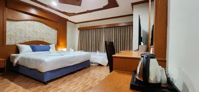 a bedroom with a bed and a desk and a tv at Arya Suites Patong Beach in Patong Beach