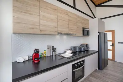 a kitchen with a black counter top and wooden cabinets at Trendy & New 19m Oxygen Pool Villa Sunset Garden 10 in Rawai in Rawai Beach