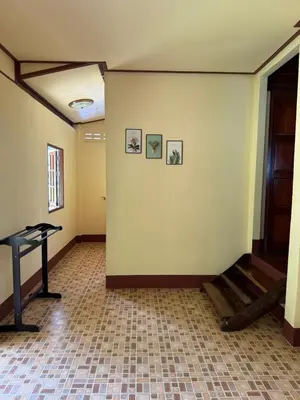 an empty room with a table and pictures on the wall at Chaba House Koh Yao Noi in Ban Laem Sai