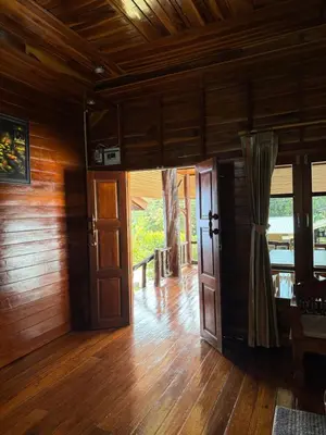 an empty room with wooden walls and wooden floors and doors at Chaba House Koh Yao Noi in Ban Laem Sai