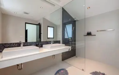 a bathroom with two sinks and a glass shower at 15 - Ocean View Oasis in Kalim Beach in Patong Beach