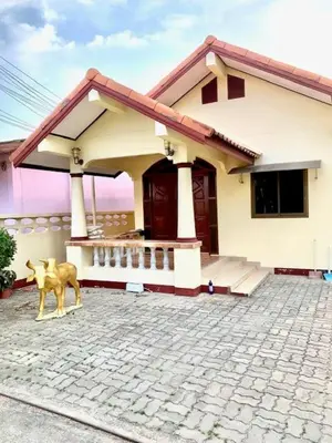 a house with a dog standing in front of it at Bangtao15 Private House in Surin Beach