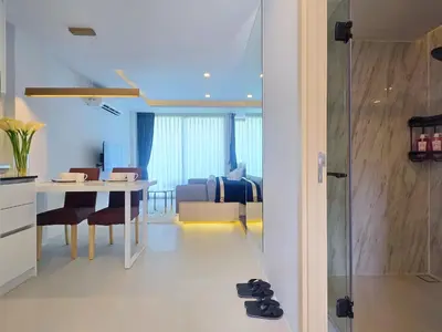 a kitchen and living room with a table and chairs at Karon Utopia in Karon Beach