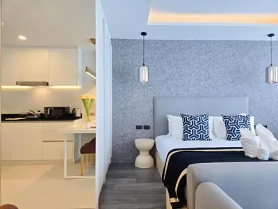a bedroom with a bed with blue and white pillows at Karon Utopia in Karon Beach