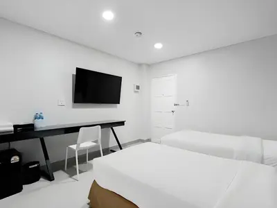 a white bedroom with a desk and a television at Terminal2 Hotel Phukettown in Phuket Town