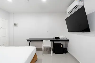 a bedroom with a desk with a chair next to it at Terminal2 Hotel Phukettown in Phuket Town