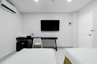 a bedroom with a desk and a tv on a wall at Terminal2 Hotel Phukettown in Phuket Town