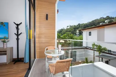 a balcony with a table and chairs and a view at Newly Built 3BR Pool Villa Goldena 12B in Kamala in Kamala Beach