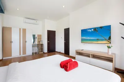 a bedroom with a white bed with a red pillow at Newly Built 3BR Pool Villa Goldena 12B in Kamala in Kamala Beach