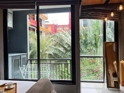 a room with a view of a garden outside a window at ReLife The Windy Naiharn in Rawai Beach