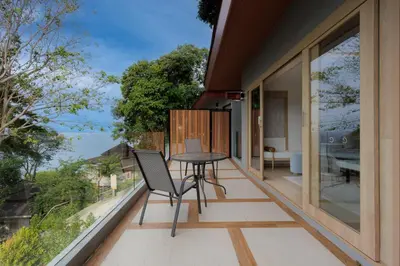 a room with a balcony with a table and chairs at Centara Villas Phi Phi Island in Phi Phi Don